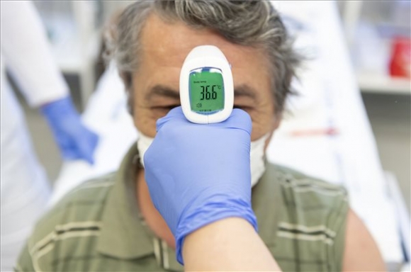 Megmérik egy férfi testhőmérsékletét, mielőtt beoltják az AstraZeneca koronavírus elleni vakcina első adagjával Mike Judit háziorvos nyíregyházi rendelőjében 2021. április 9-én (MTI/Balázs Attila)