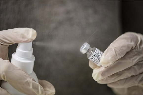 Az asszisztens lefertőtleníti a Pfizer-BioNTech koronavírus elleni vakcina üvegét Bojti István nyíregyházi háziorvosi rendelőjében 2021. április 22-én (MTI/Balázs Attila)