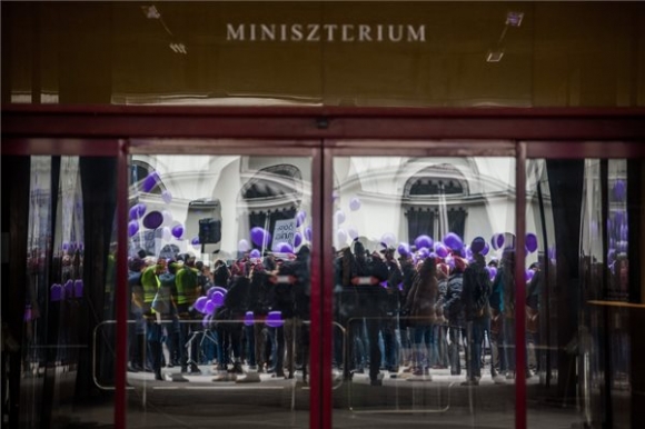 A Független Egészségügyi Szakszervezet (FESZ) Tüntetés a magyar egészségügyért! elnevezésű demonstrációjának résztvevői tükröződnek az Emberi Erőforrások Minisztériuma Arany János utcai épületének ablakában 2018. március 24-én. MTI Fotó: Balogh Zoltán
