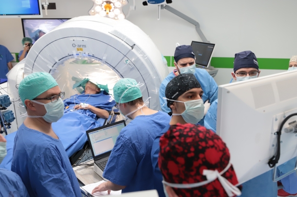 Együttműködésben a betegért: a műtétet végző orvoscsoport három dimenziós intraoperatív képalkotás (O-armTM) mellett helyezi be a mélyagyi stimulációs elektródát. Fotó: Bobkó Anna, SZTE Nemzetközi és Közkapcsolati Igazgatóság