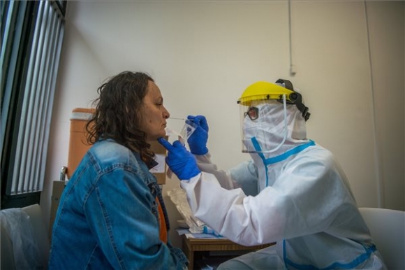 Védőfelszerelést viselő ápoló koronavírusteszthez vesz mintát egy betegtől az Országos Korányi Pulmonológiai Intézetben 2020. május 5-én (MTI/Balogh Zoltán)