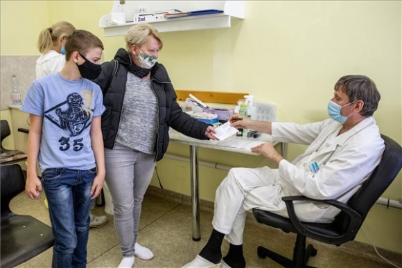 Liechtestein-Zábrák József orvos átadja az oltási igazolást egy nőnek, miután gyermekét beoltották a német-amerikai fejlesztésű Pfizer-BioNTech koronavírus elleni oltóanyag, a Comirnaty-vakcina második adagjával a békéscsabai Réthy Pál kórházban 2021. október 16-án (MTI/Rosta Tibor)