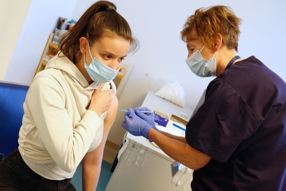 Egy nőt beoltanak a német-amerikai fejlesztésű Pfizer-BioNTech koronavírus elleni oltóanyag harmadik adagjával a kaposvári Somogy Megyei Kaposi Mór Oktató Kórházban 2021. december 8-án az oltási akció keretében. Fotó: MTI/Varga György