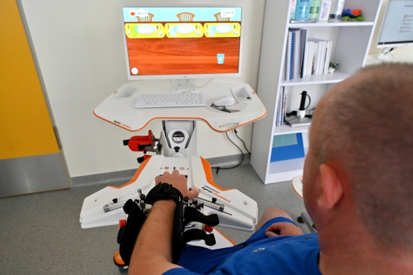 Kezelés a Tyromotion cég által gyártott Amadeo nevű, robot által támogatott ujj-kéz rehabilitációjára szolgáló tréningeszközzel (Fotó: MTI/Purger Tamás)