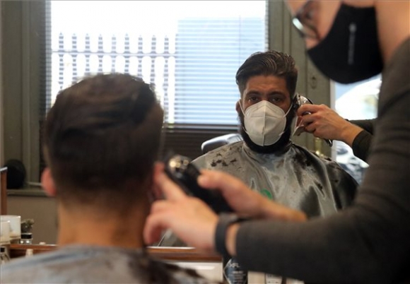 Juhos Gergő fodrász egy férfi haját vágja egy újranyitott miskolci szalonban 2021. április 7-én (MTI/Vajda János)